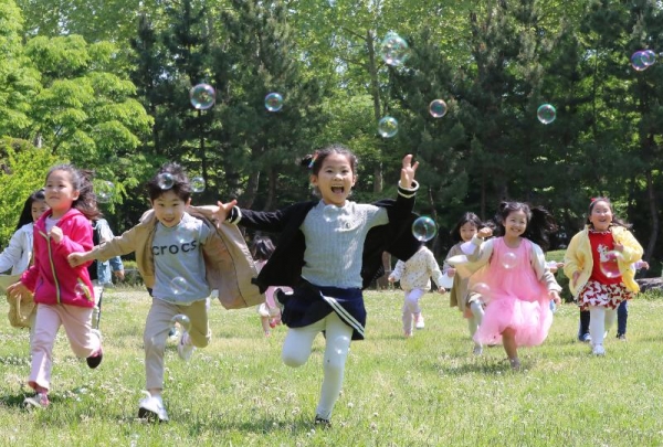 Children from the daycare center of Gwangju's Buk-gu District on the morning of May 3, two days ahead of the centennial anniversary of Children's Day, run after bubbles at the campus of Chonnam National University in the city. (Yonhap News)