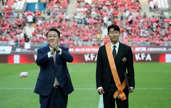 President Yoon Suk Yeol on June 2 claps after giving the Cheongnyong Medal to Son Heung-min, a star striker for Tottenham Hotspur of the English Premier League, at Seoul World Cup Stadium in the city's Mapo-gu District, where a friendly match between the national soccer team and Brazil was played.