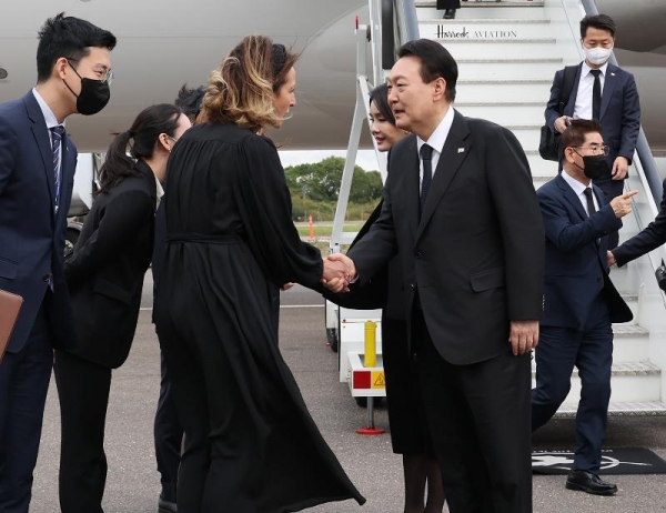 President Yoon Suk Yeol and first lady Kim Keon Hee on Sept. 18 are greeted by British officials after arriving at London Stansted Airport (Yonhap News).