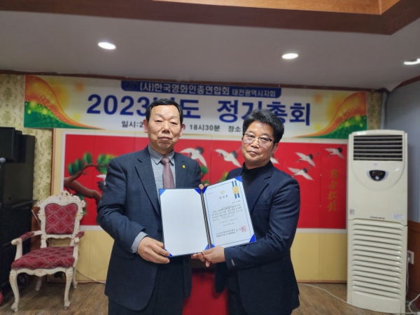 Election management committee chairman Seong Nak-won (left in the photo) presenting the certificate of election to newly elected Chairman Kim Hong-hyun (right in the photo).