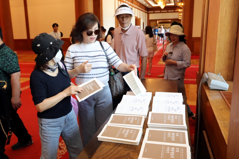 Visitors to the exhibition "Stories of Our Presidents: The Presidents Were Here" look at the brochure at the venue inside the main building of Cheong Wa Dae.